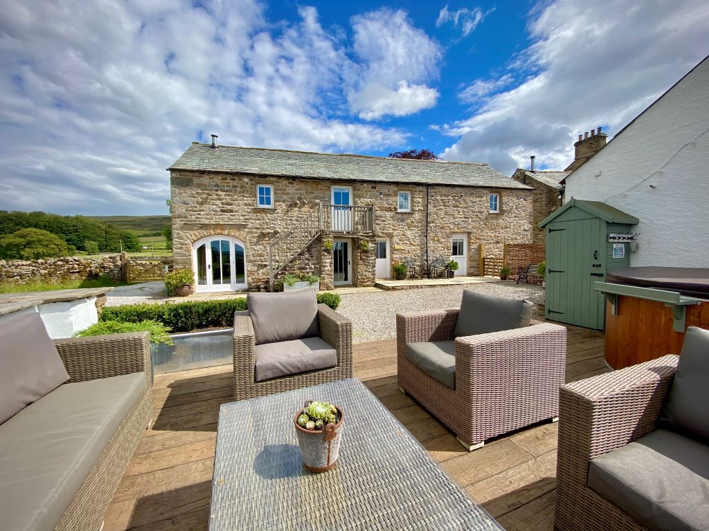 Countryside stone cottage with modern outdoor seating area.