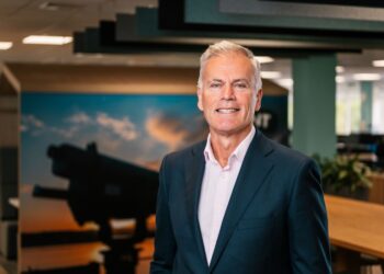 Businessman in an office with a telescope background.