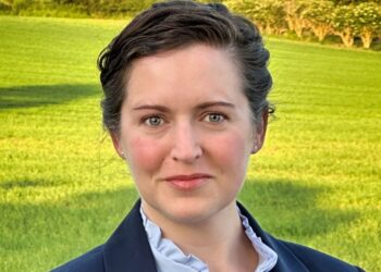 Woman in a field with a suit.