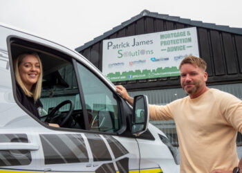 Patrick James Solutions building with two smiling individuals.