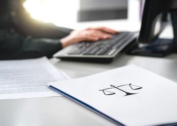 Typing on keyboard with legal documents nearby
