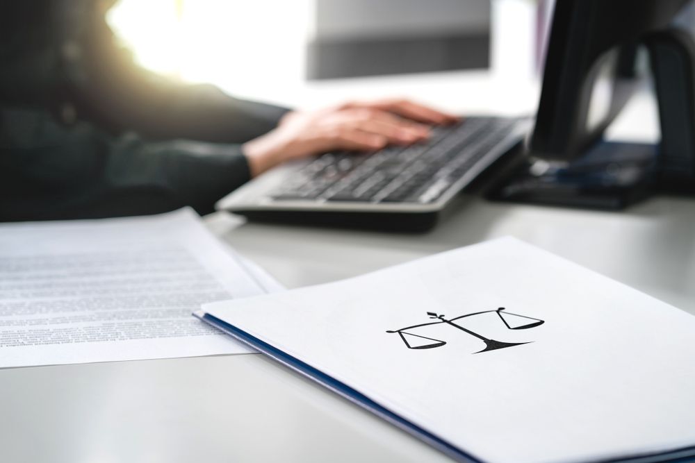 Typing on keyboard with legal documents nearby
