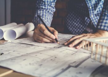 Architect drawing plans on desk.