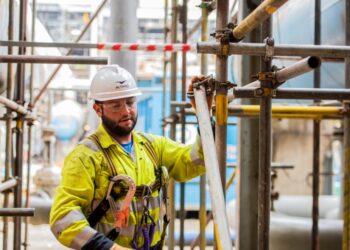 Construction worker assembling scaffolding