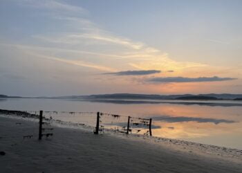 Sunset over calm lake with distant hills