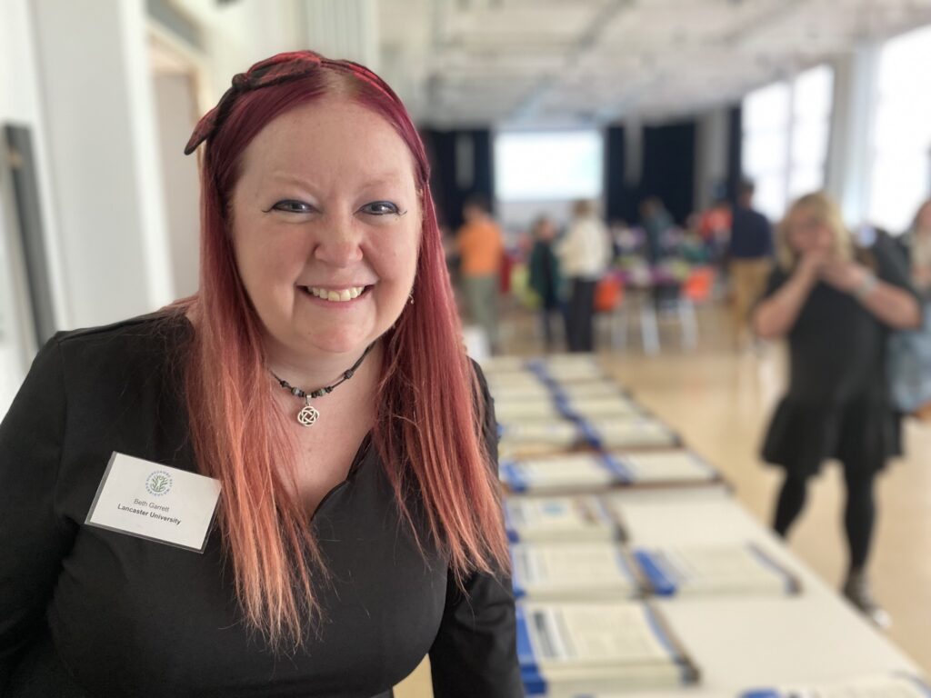 Smiling woman at conference with her name tag.