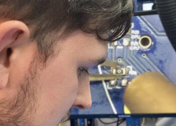 Technician soldering a circuit board