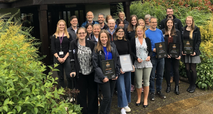 Group photo of award winners outside a building.