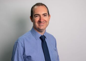 Smiling man in blue checkered shirt and tie