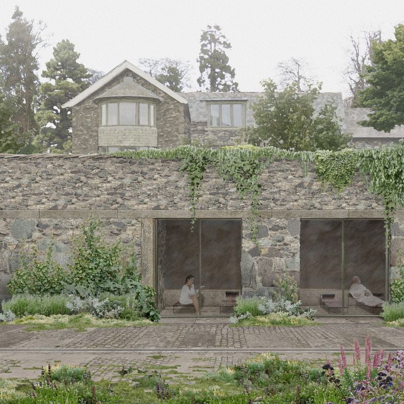 Stone house with greenery and people in garden.
