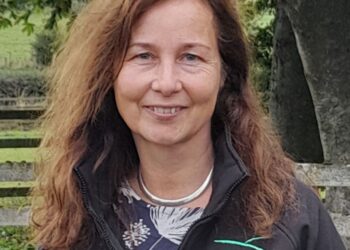 Woman in black Farmer Network jacket.