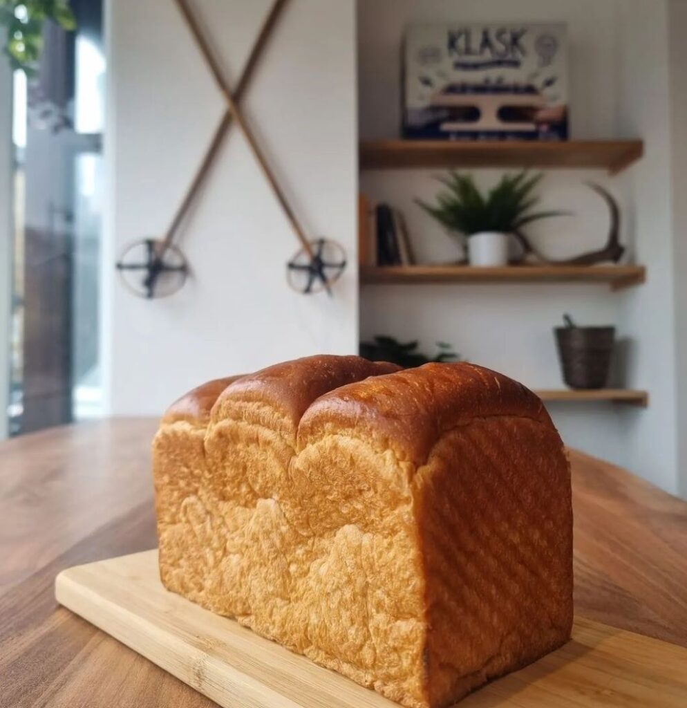 Fresh loaf of bread on a wooden table.