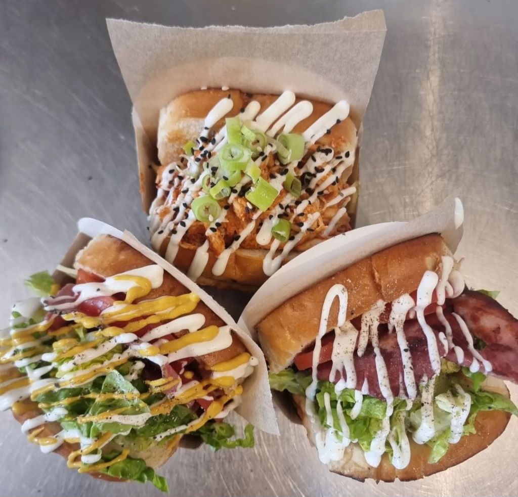Three gourmet sandwiches with various toppings