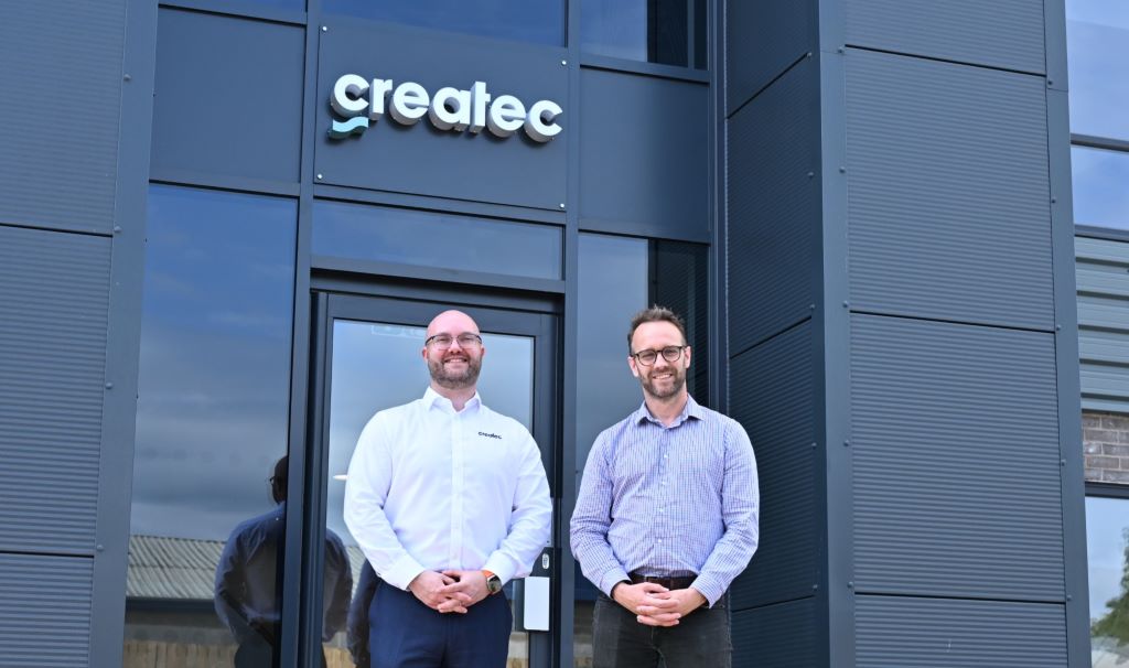 Two men standing in front of Createc building