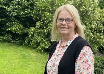 Woman standing in a lush green garden.