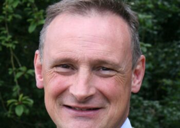 Smiling man outdoors with green background