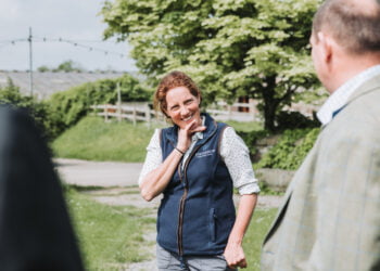 Farmers conversing outdoors on a sunny day.
