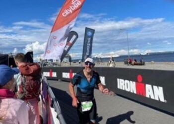 Triathlete running in Ironman race by the sea.