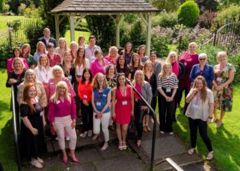 Group of smiling people by a garden gazebo