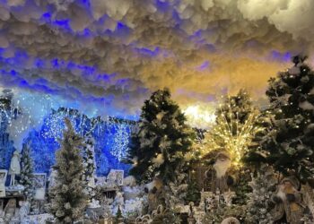 Christmas decorations, Santa figures, trees, and illuminated background.