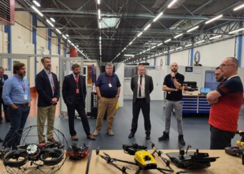 Group observing drone technology in a workshop