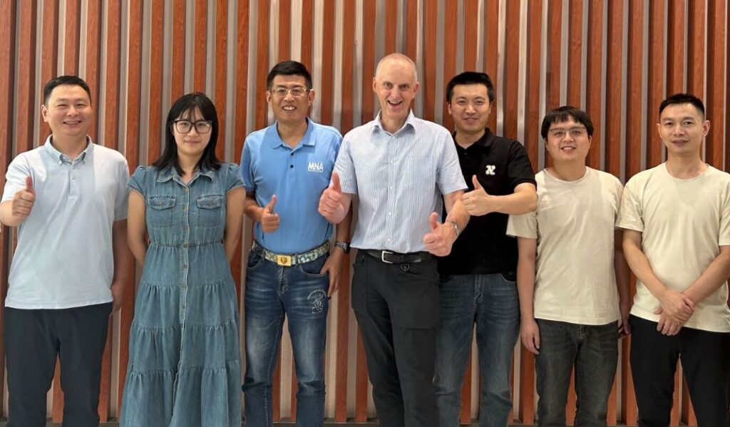 Team members standing together, thumbs up
