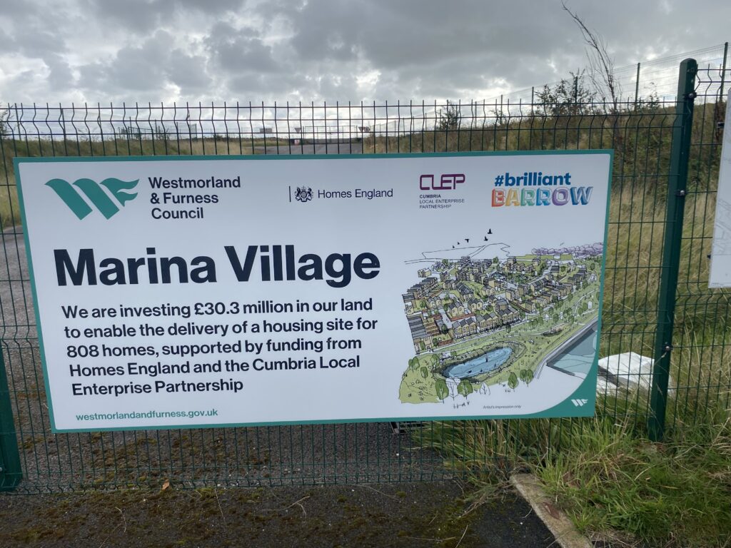 Marina Village housing development sign on fence