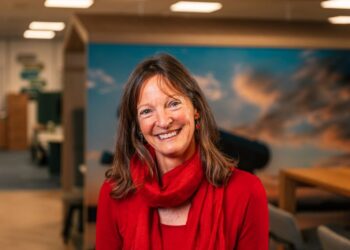 Woman in red smiling in office