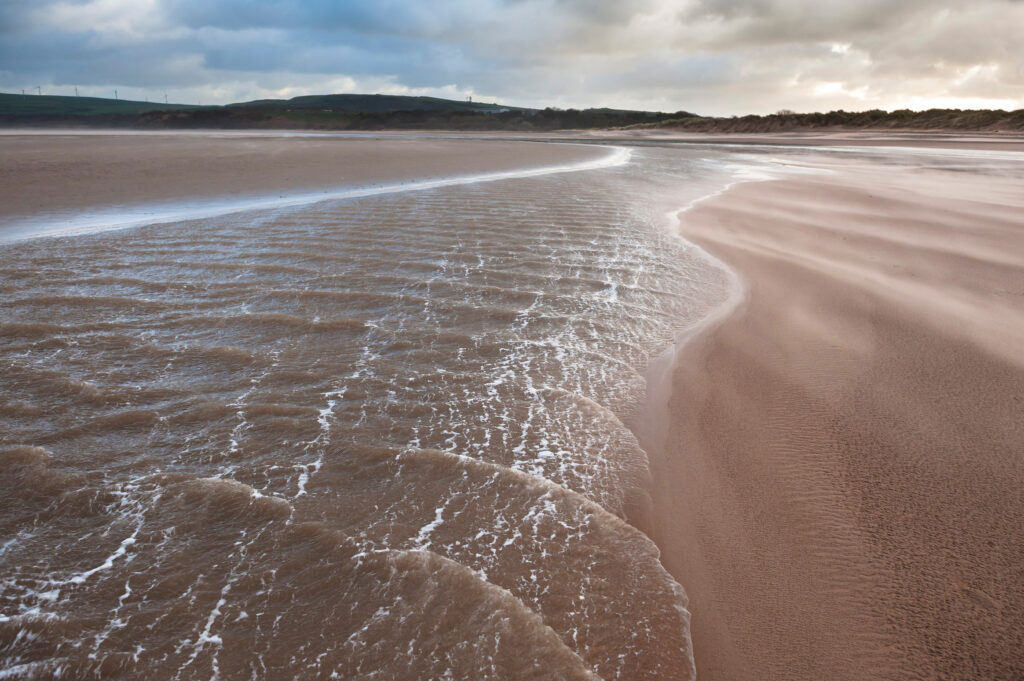 Calm tide on expansive sandy beach