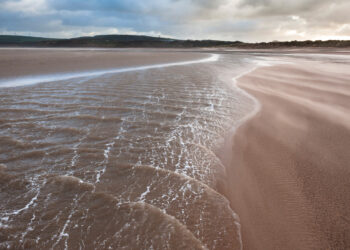 Calm tide on expansive sandy beach