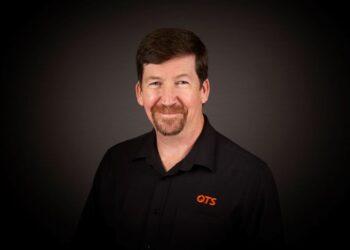 Smiling man in black QTS shirt portrait