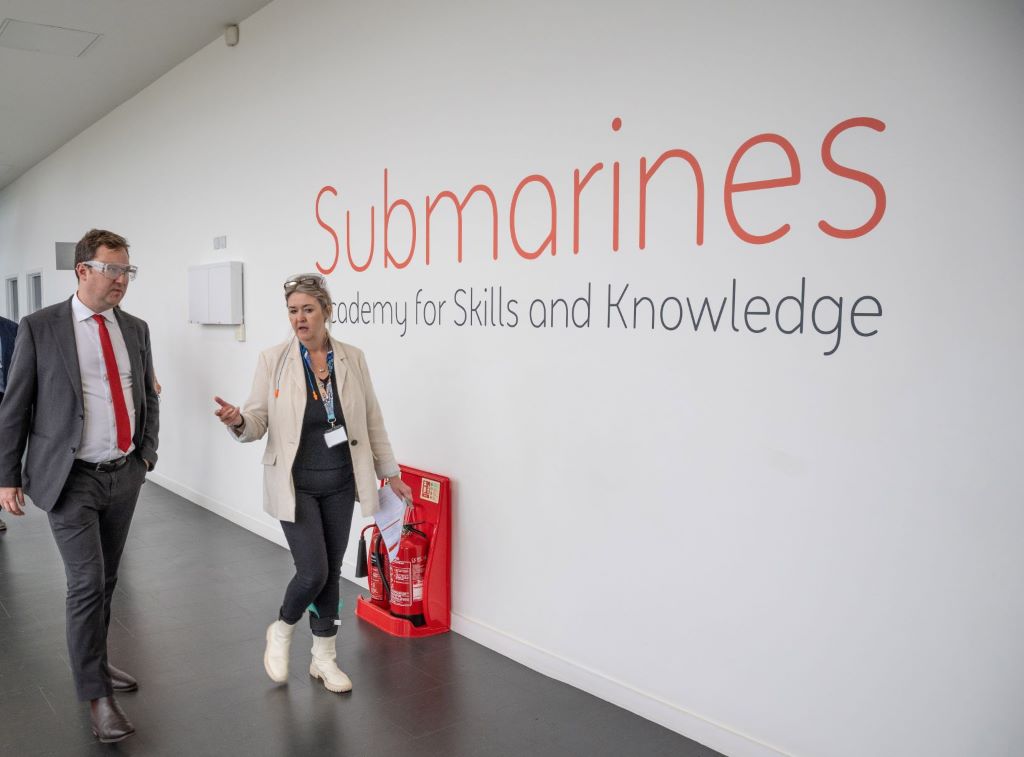 People walking past Submarines Academy sign.