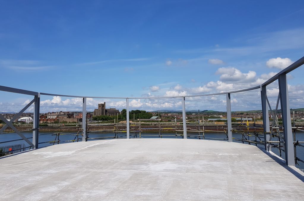 Rooftop view of riverside townscape on sunny day.