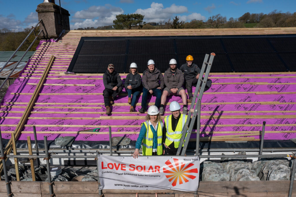 Workers installing solar panels on a roof