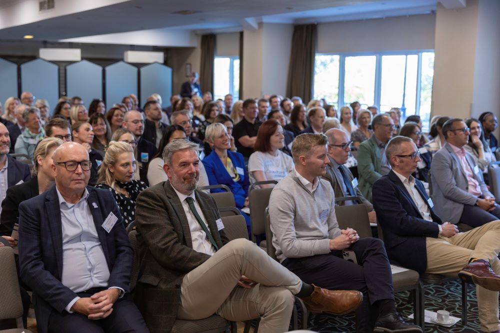 Audience attentively listens during conference presentation.