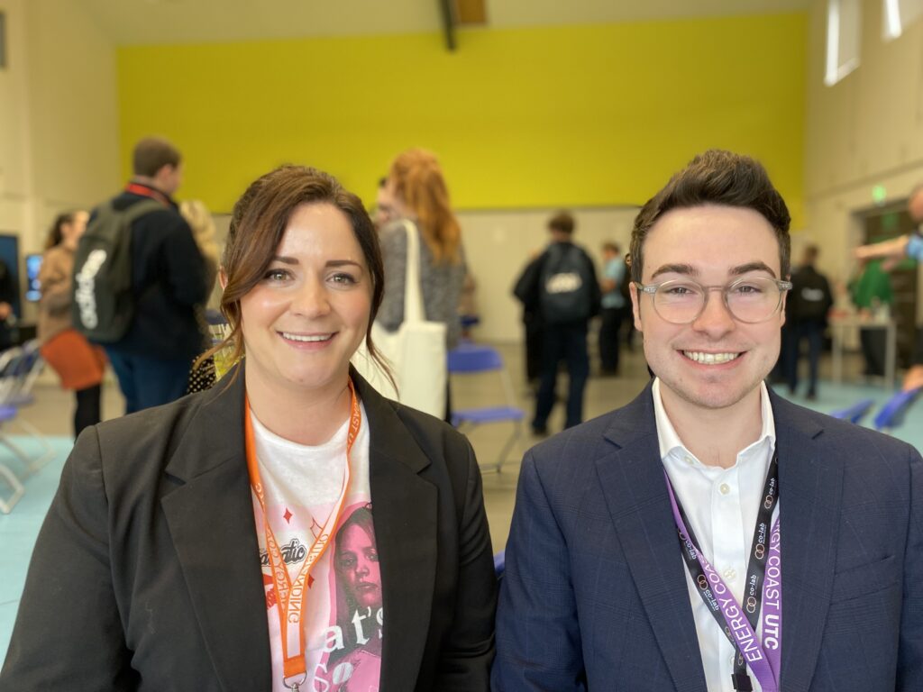 Two people smiling at a networking event.