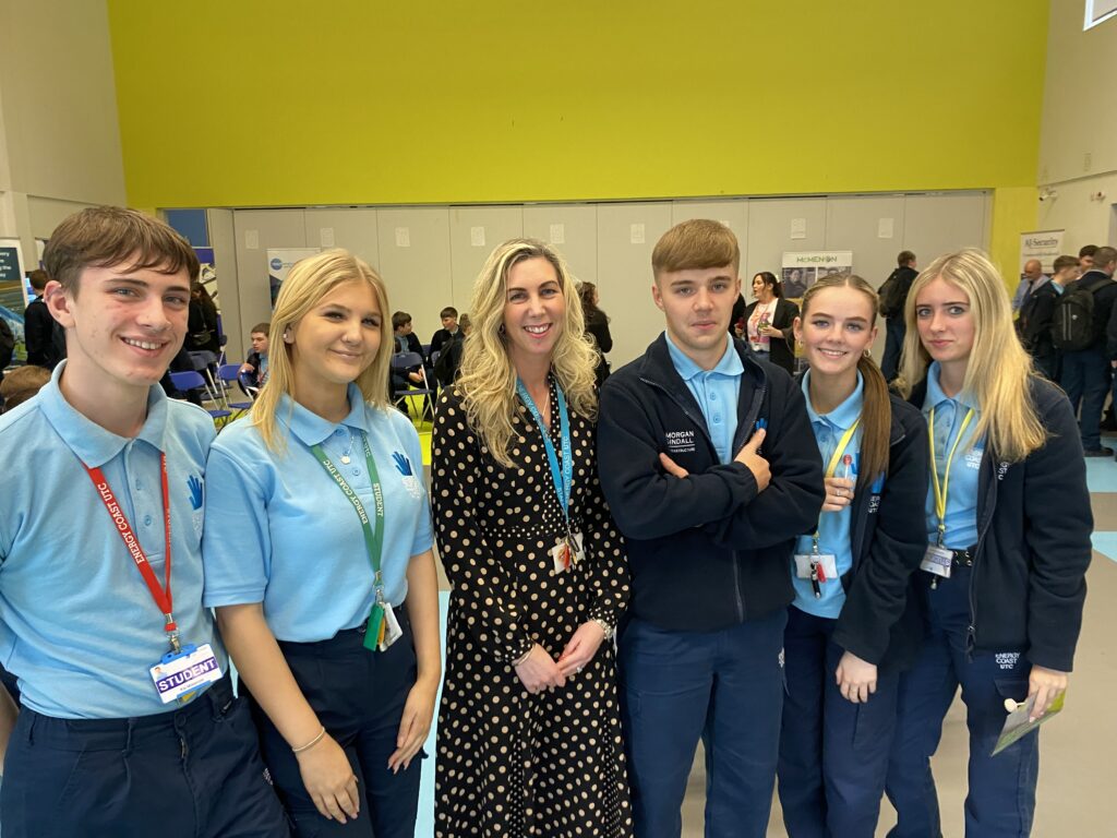 Group of students with a woman at an event.