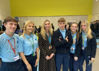 Group of students with a woman at an event.