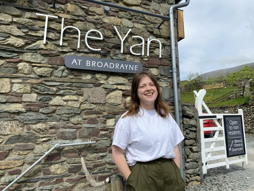Smiling woman at The Yan restaurant entrance.