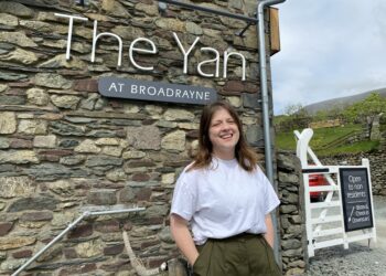 Smiling woman at The Yan restaurant entrance.
