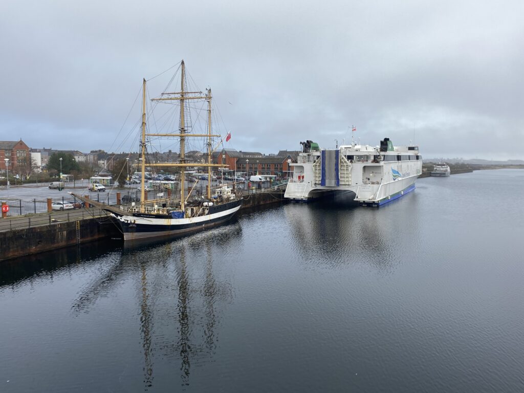 Ships docked in a harbour on a cloudy day.