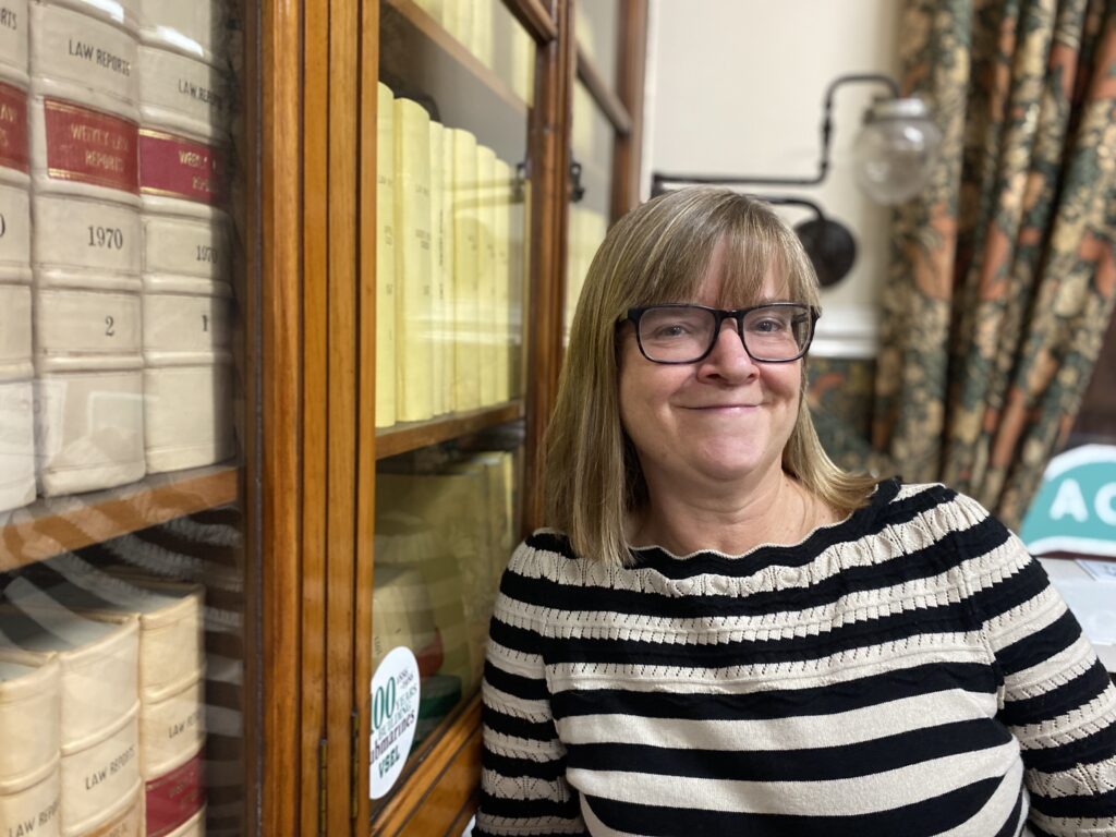 Woman in library with law books.