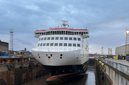 Large ferry docked for maintenance at shipyard.