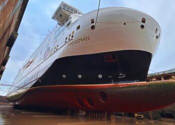 Large ship in dry dock, viewed from below.