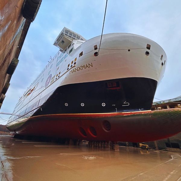 Large ship in dry dock, viewed from below.
