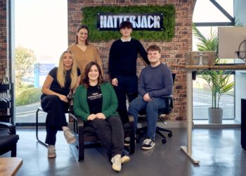 Five people posing in front of Natterjack sign.