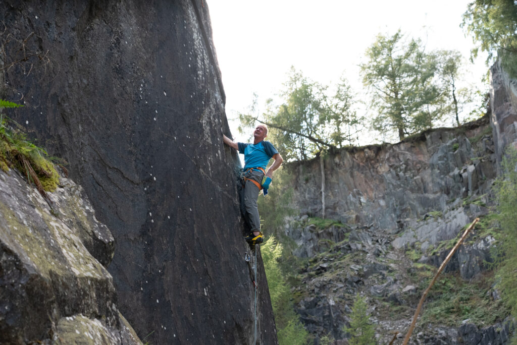 Person rock climbing on a steep cliff face.