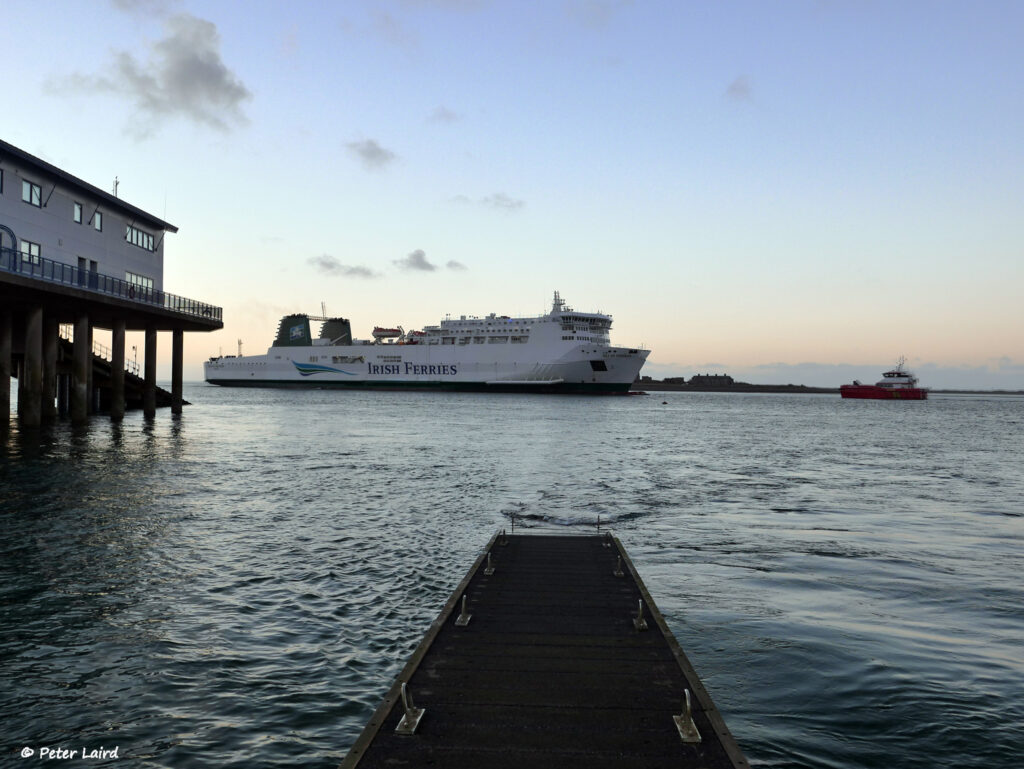 Irish Ferries ship near dock at sunset.