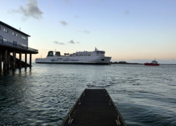 Irish Ferries ship near dock at sunset.