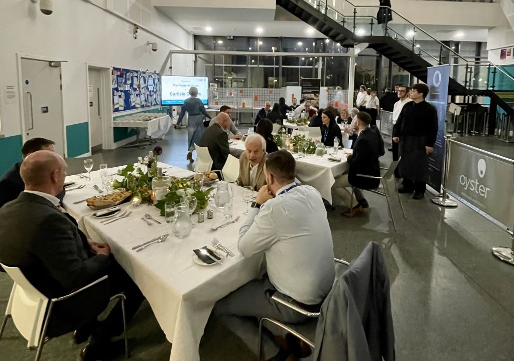 Formal dinner event with guests and staff in hall.